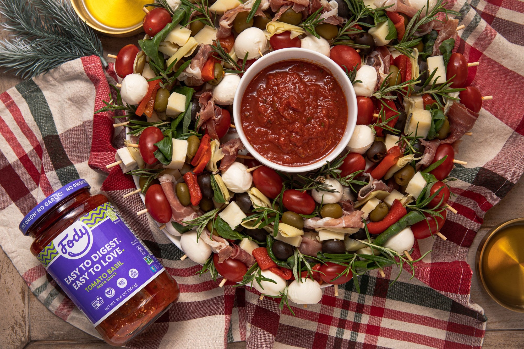 Jar of Fody Foods tomato basil pasta sauce on top of an assortment of kebabs