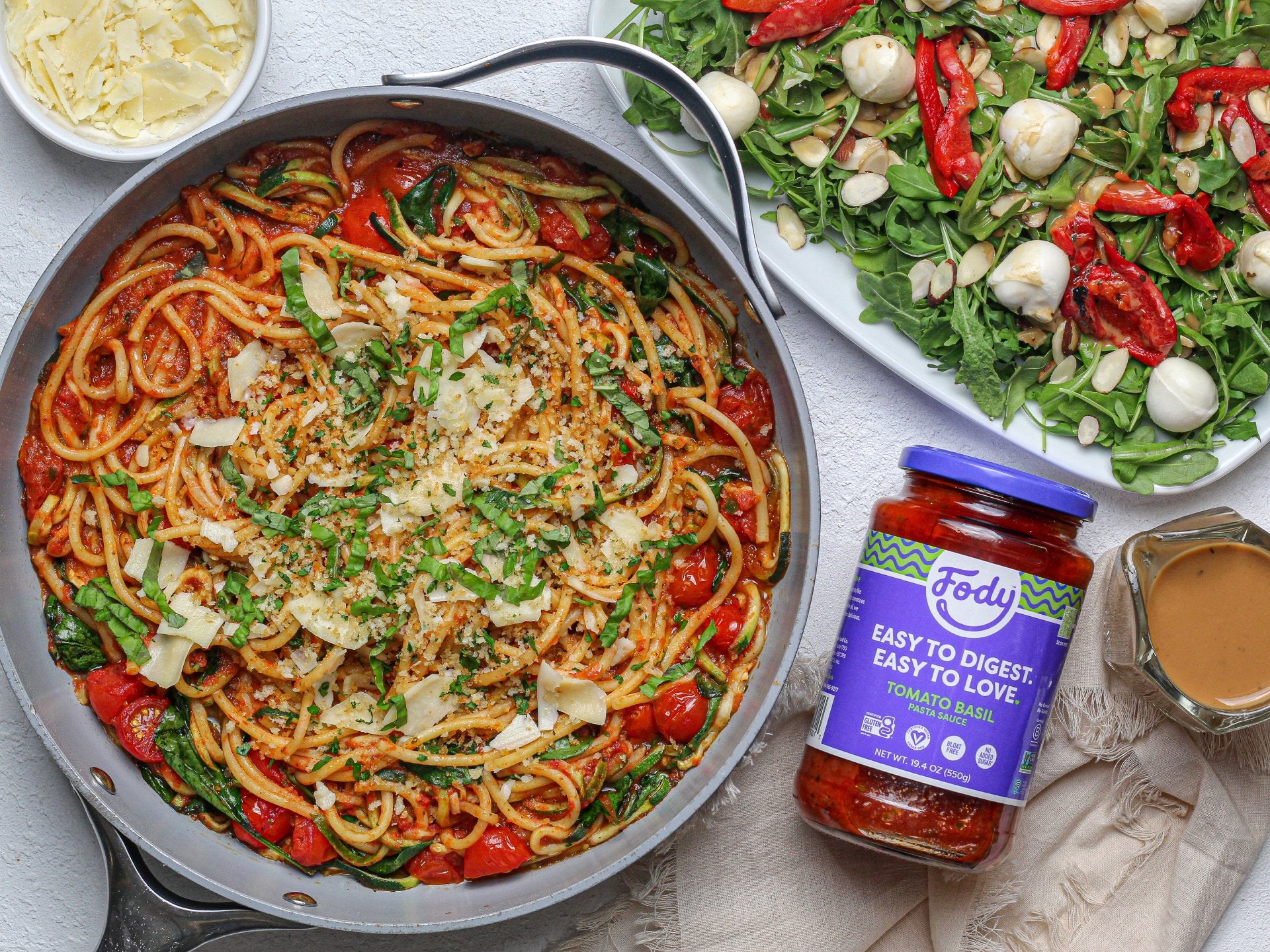 Fody tomato basil sauce next to a spaghetti dish