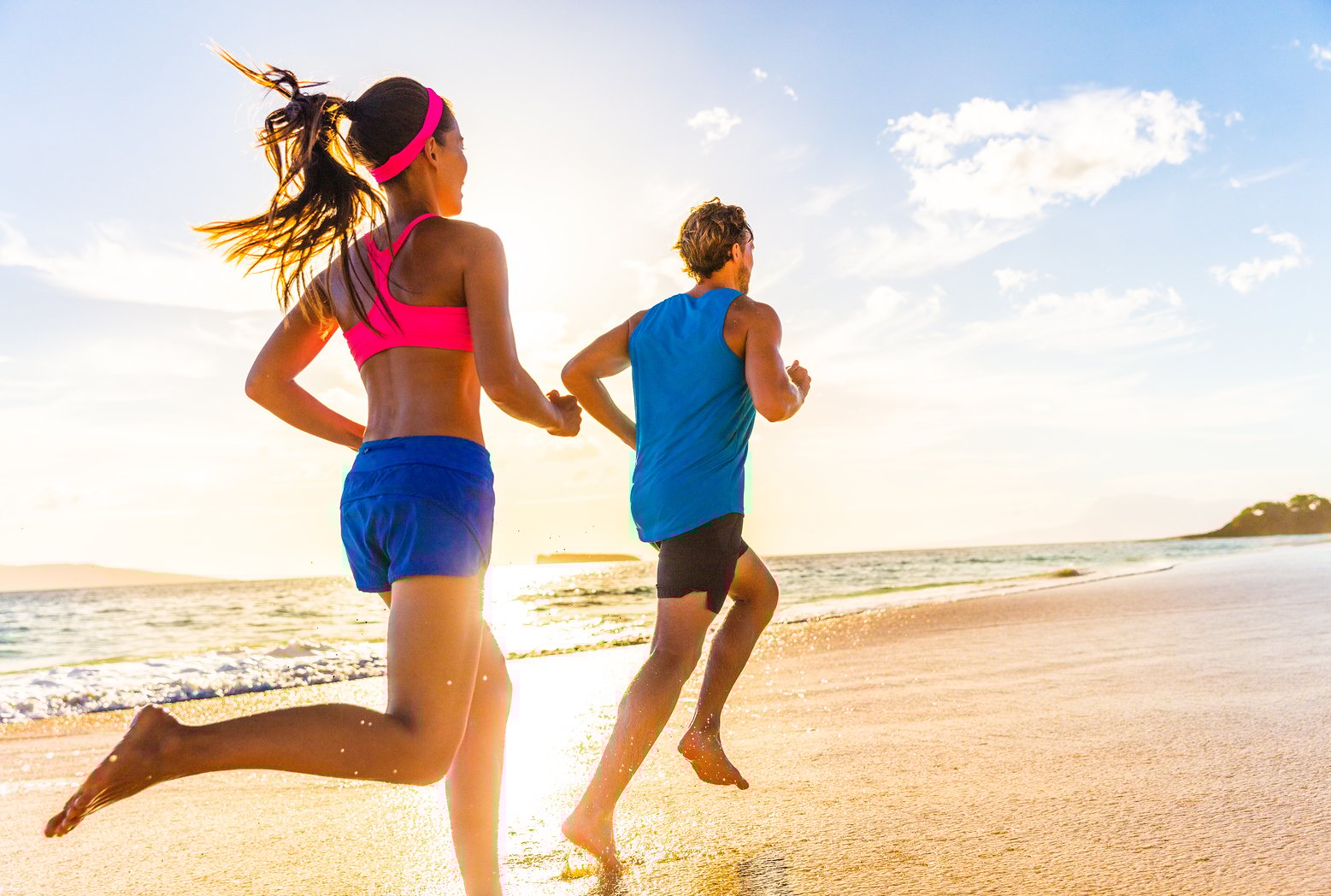 A man and woman running on a beach
