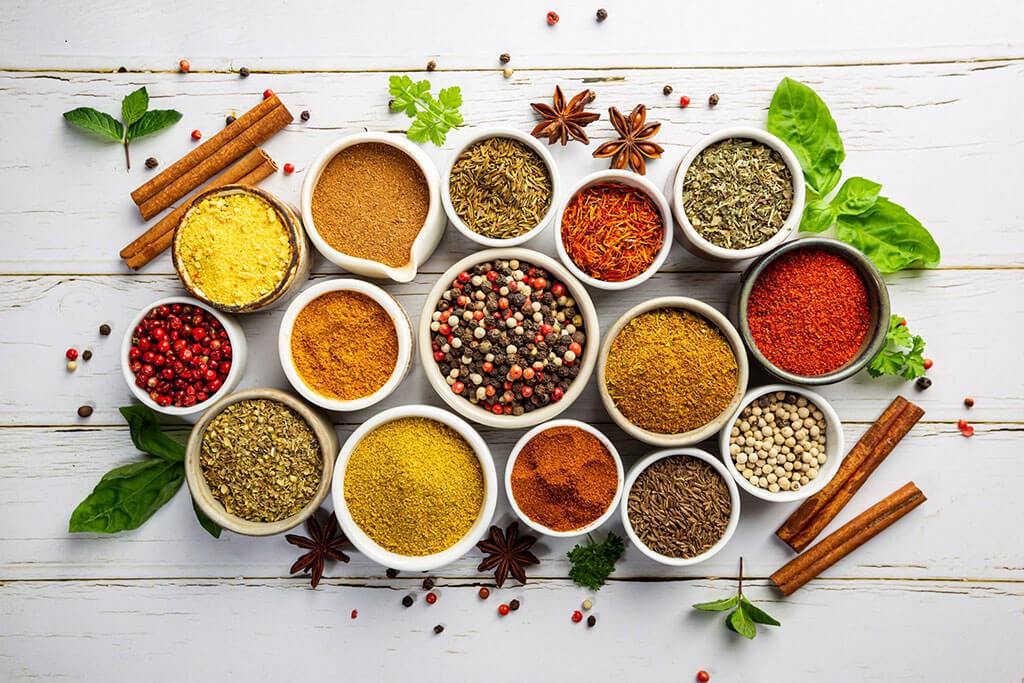 Bowls of colorful FODMAP-safe spices arranged on a table