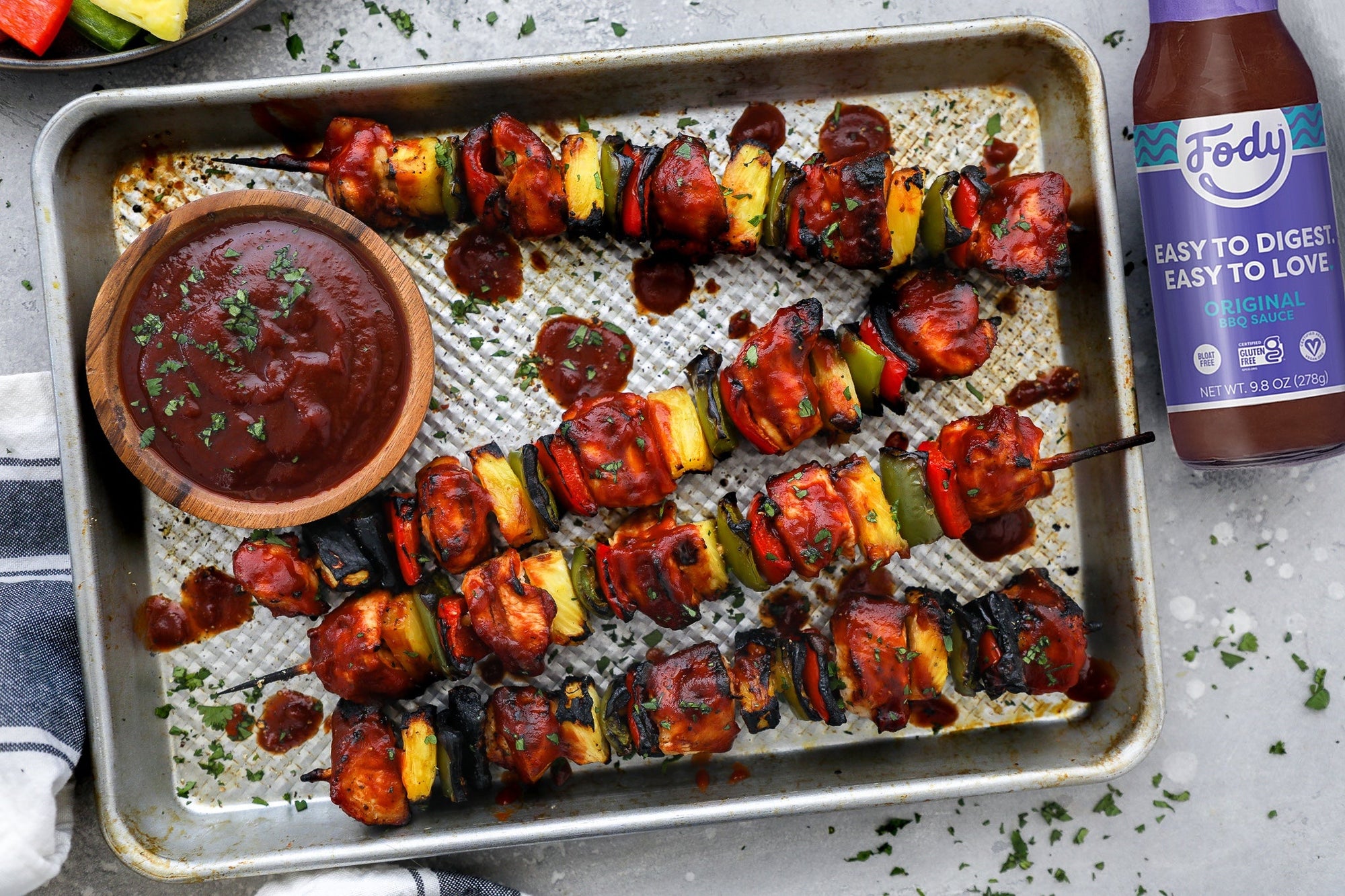 An image of a baking sheet covered in low FODMAP chicken skewers with pineapple, peppers and BBQ sauce.