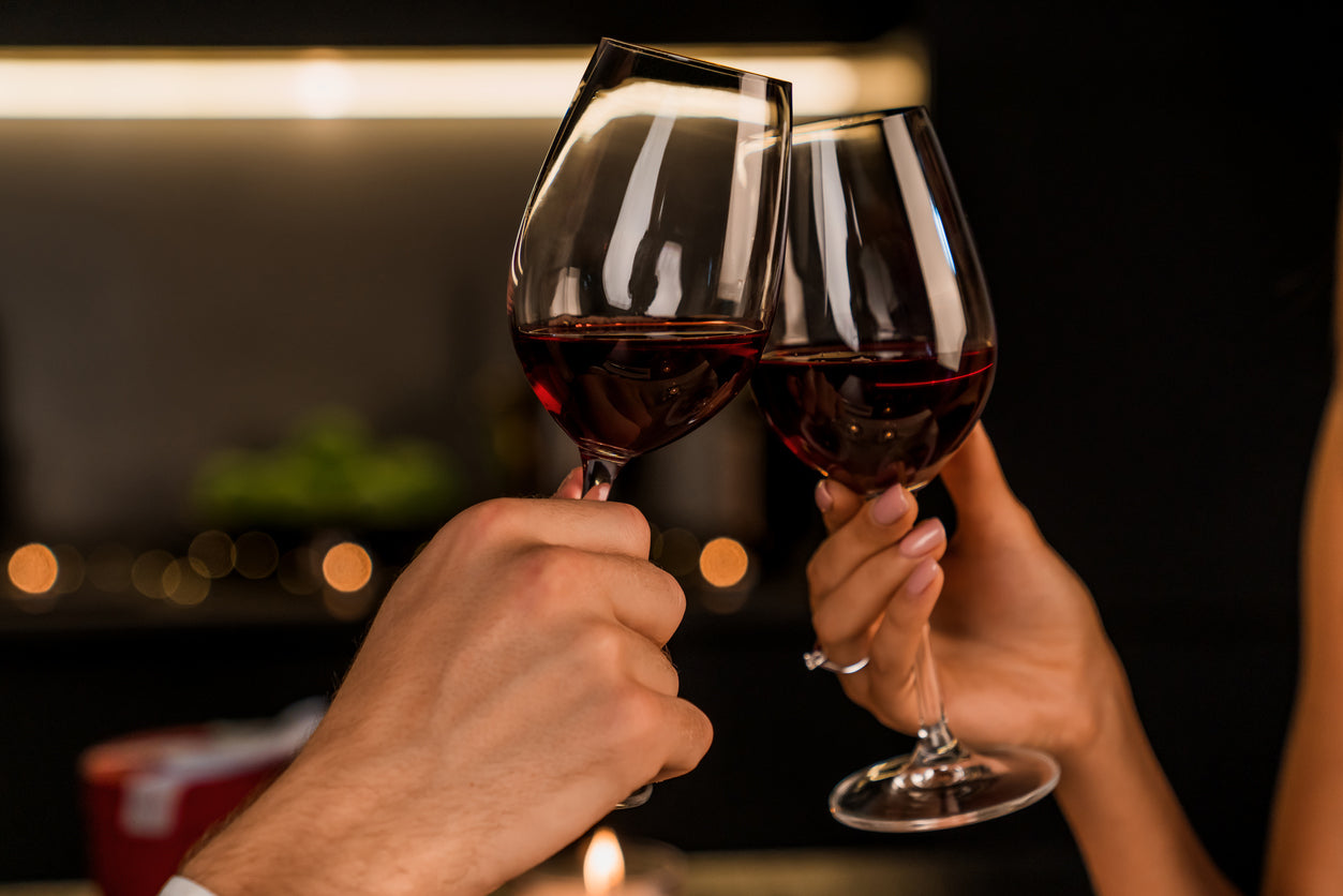 Dating with IBS is a challenge, but with proper strategies in place, you can enjoy yourself and feel confident! An image of two hands toasting glasses of red wine against an out-of-focus background.